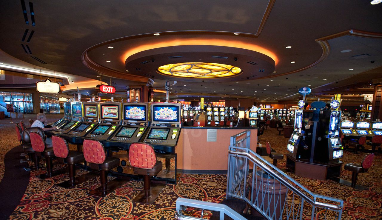 Casino interior with slot machines and seating.