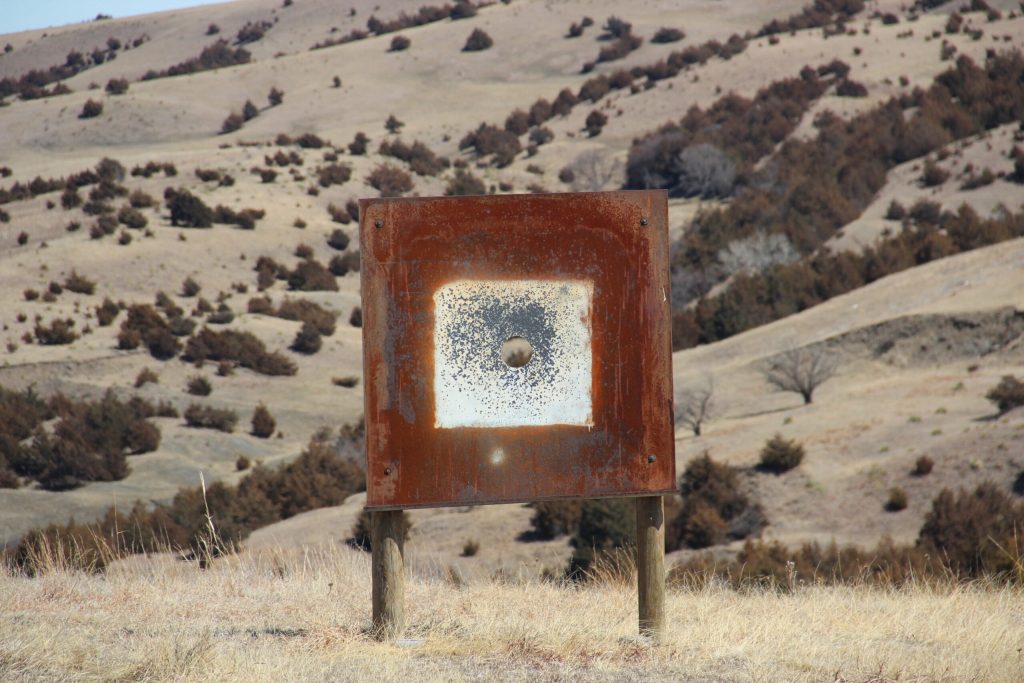 Rusty target in dry, hilly landscape.