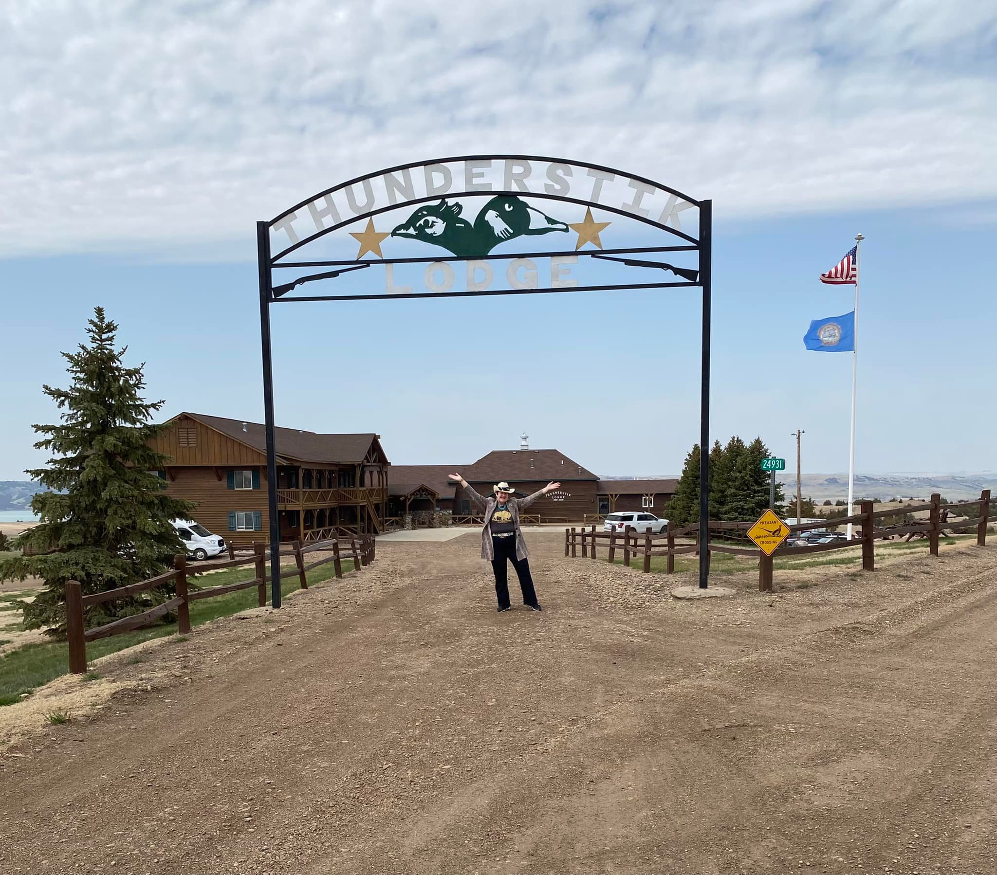Person standing under Thunderstik Lodge entrance sign.