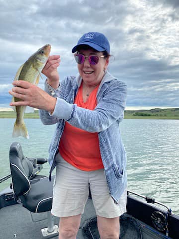 Woman holding a fish on a boat.