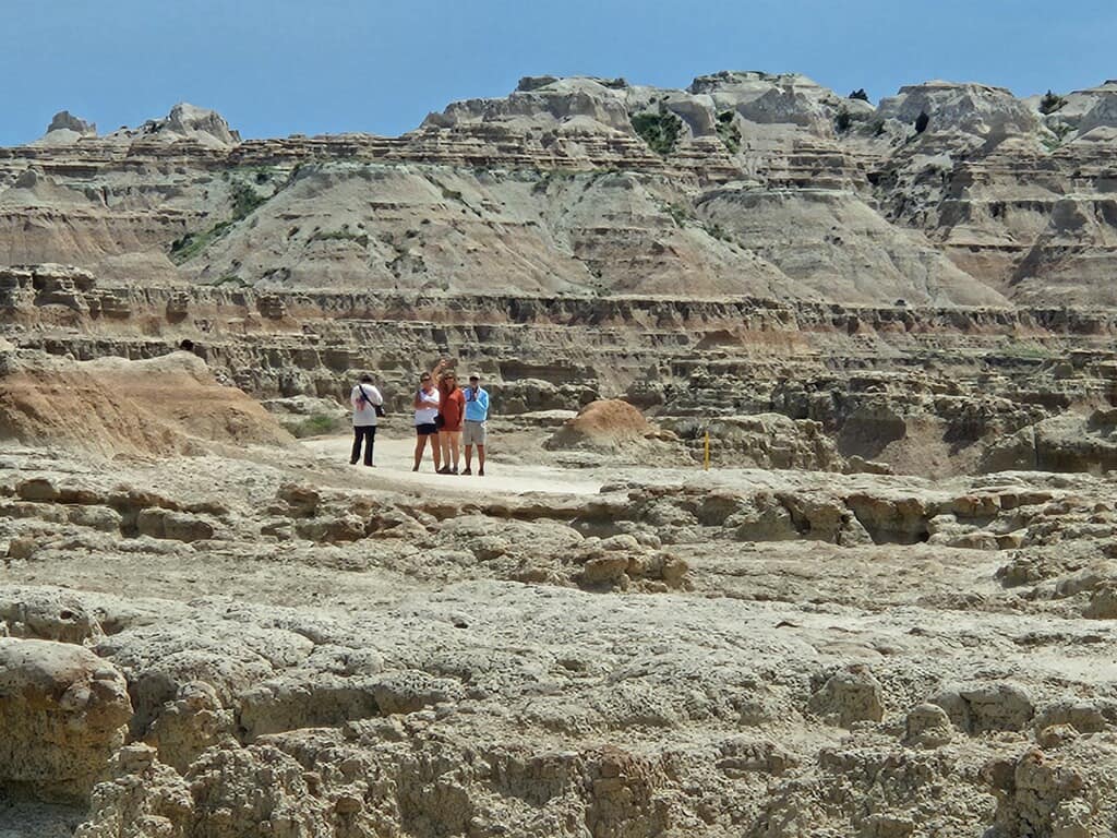 People exploring rugged desert landscape, sunny day.